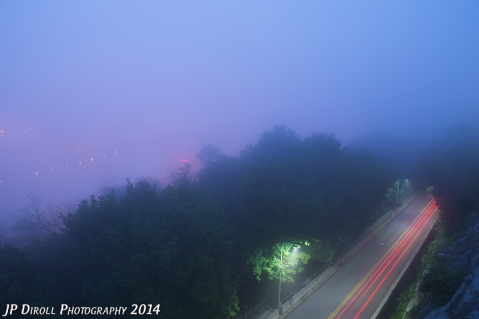Dense twilight fog blankets the city, blocking any view of the skyline.